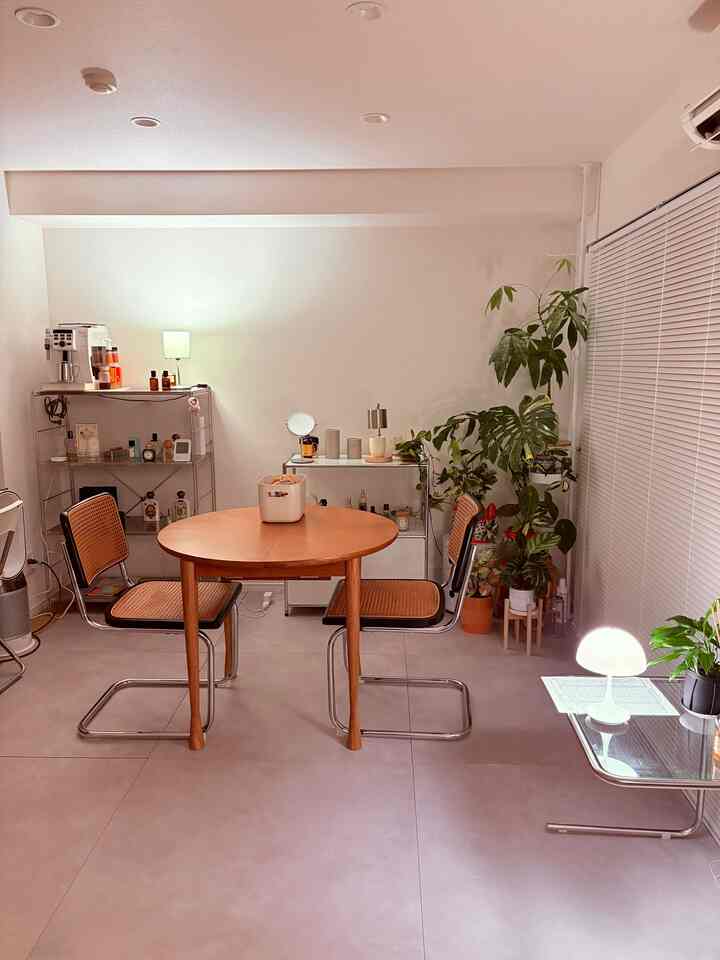 ライトグレーの床とブラウンの丸テーブルと椅子が配置された韓国インテリアのリビング空間