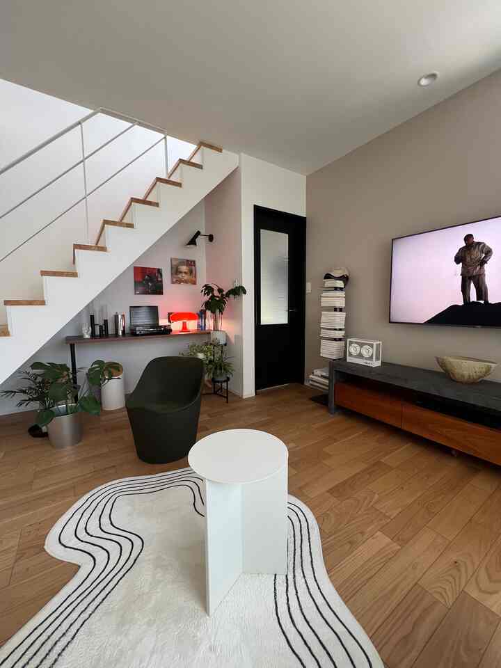 ホワイトとブラウンの色調のリビング、ミッドセンチュリーモダンのソファとサイドテーブルが配置された印象的な空間