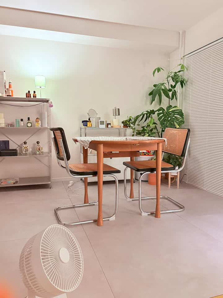 白とライトブラウンのトーンのダイニング、ミッドセンチュリーモダンのテーブルとラタンチェアが配置された雰囲気のあるインテリア