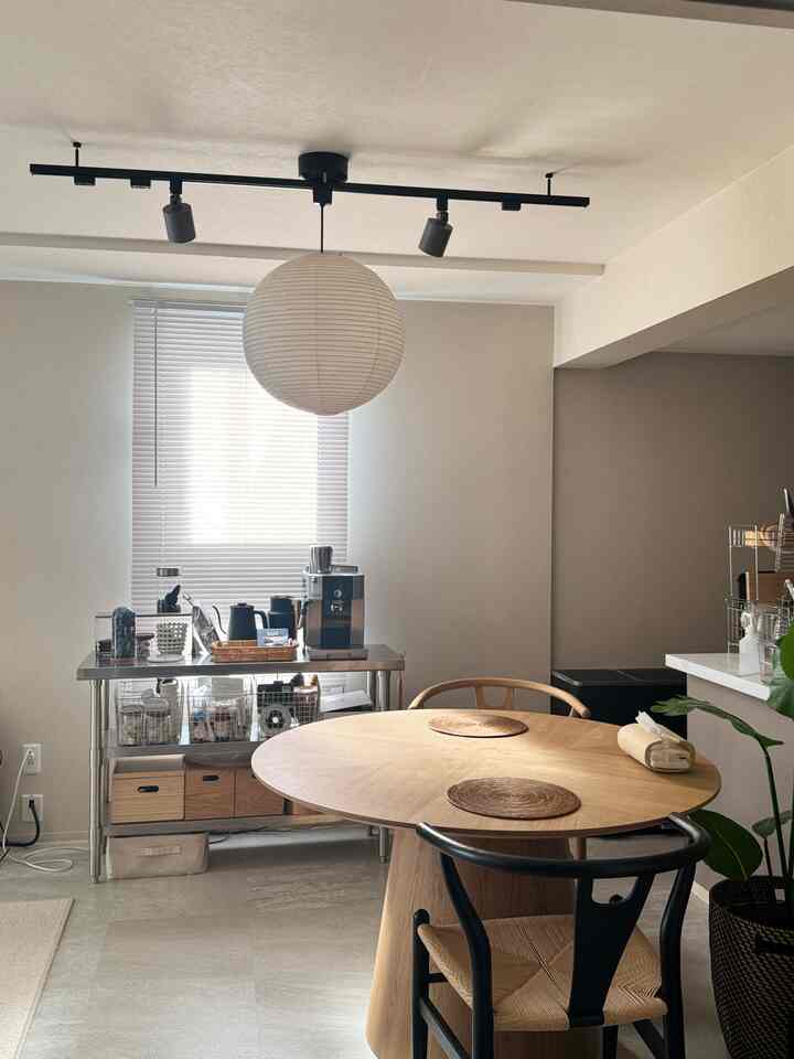 白と木目調が調和した北欧風ダイニング、丸テーブルとコーヒーステーションが配置された落ち着いた空間