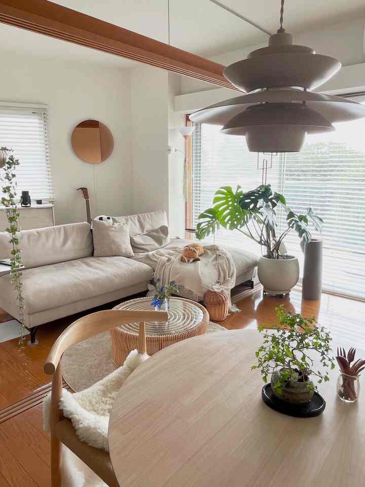Natural-toned living and dining space featuring a beige sofa and rattan coffee table with cozy Nordic style