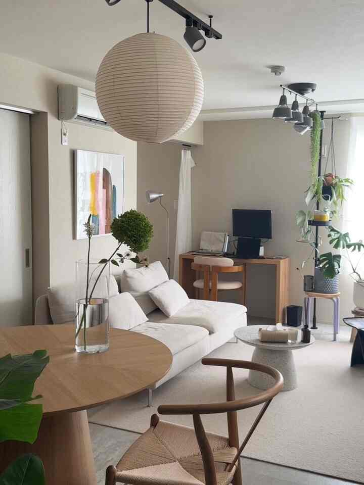 Natural-toned 2LDK living room with home office, featuring beige sofa and round wooden dining table in a simple Nordic interior