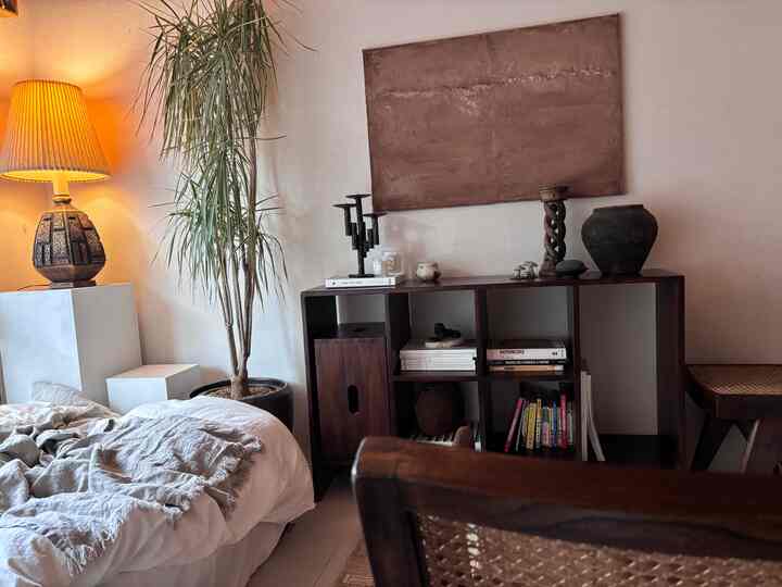 Bright white bedroom with warm brown wood furniture and natural decor, creating a cozy modern atmosphere
