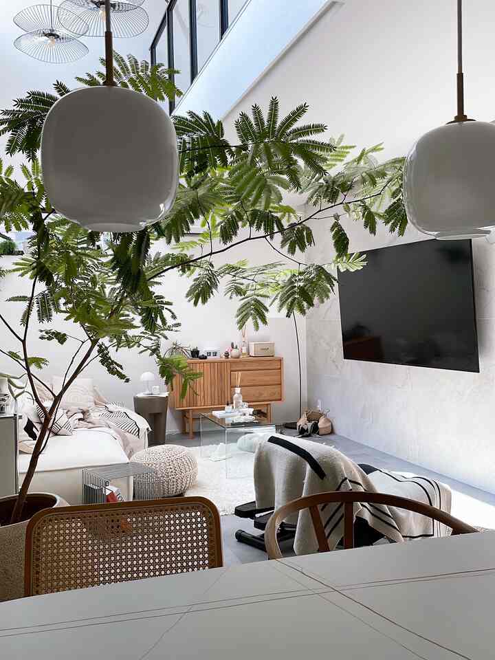 白と木目調が調和する北欧スタイルのリビングとダイニング空間、ペンダントライトと大きな窓が明るく自然な雰囲気を演出しているインテリア