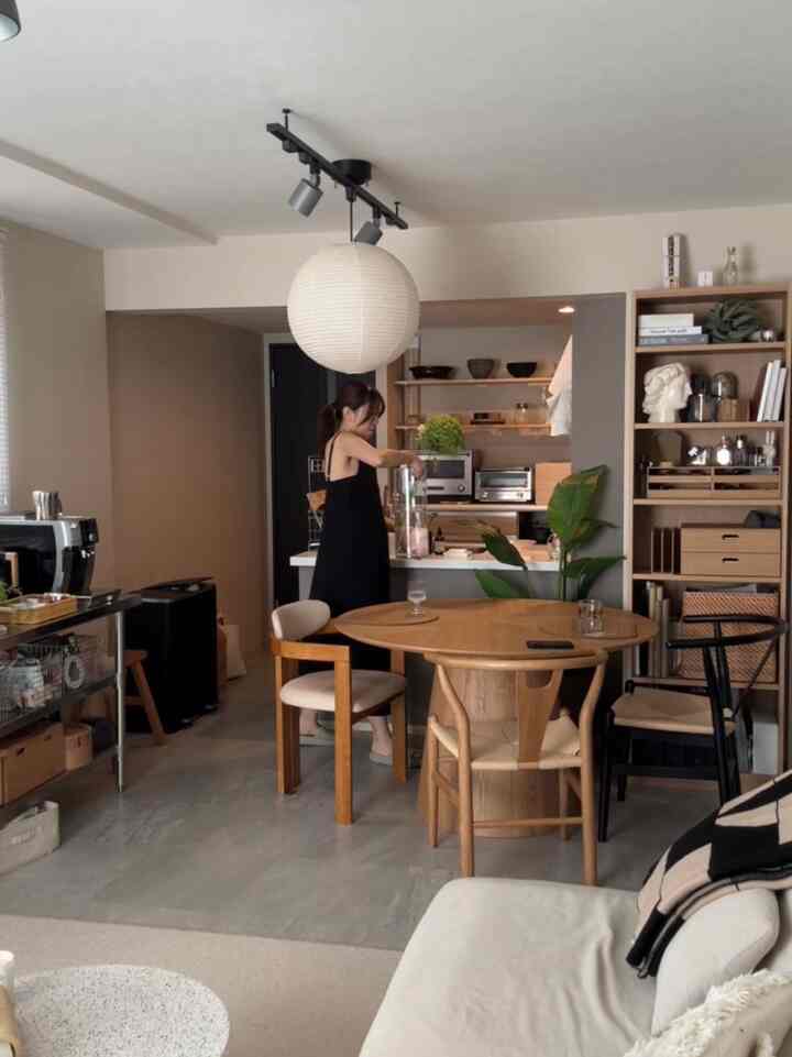 木目調と白を基調とした2LDKのキッチンとダイニング、シンプルで北欧風の家具が配置された印象的な空間