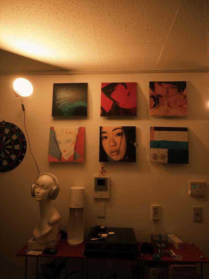 Warm brown tones and white walls define this retro-inspired workspace featuring wall art and a record turntable