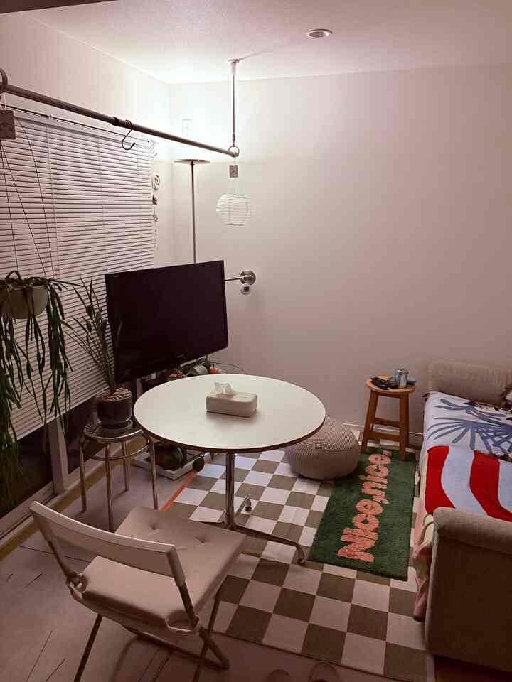 White and beige toned living room featuring round table, sofa, and rugs arranged in a cozy setting
