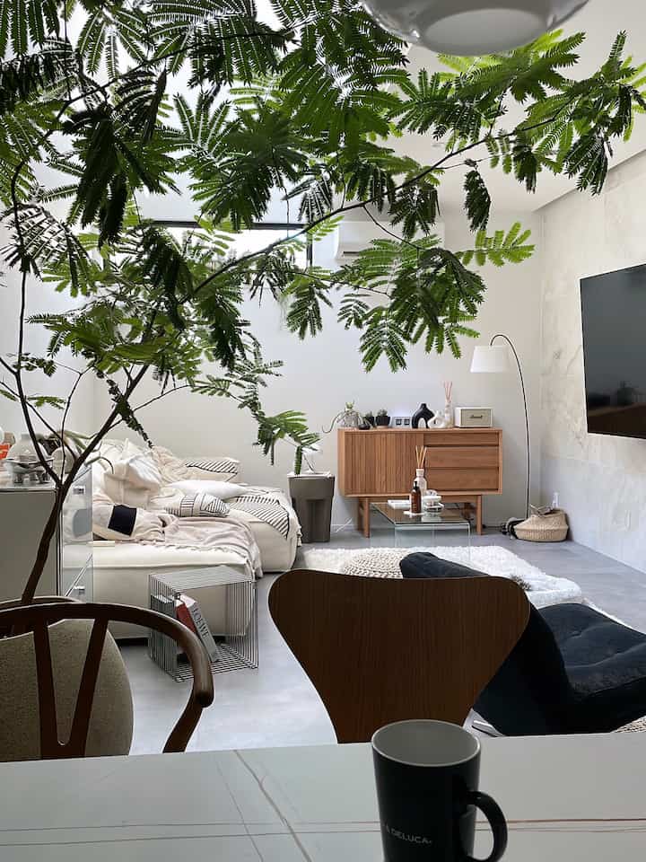 白と木目調のリビングとダイニング空間、ソファとフロアランプが配置された北欧風の雰囲気あるインテリア