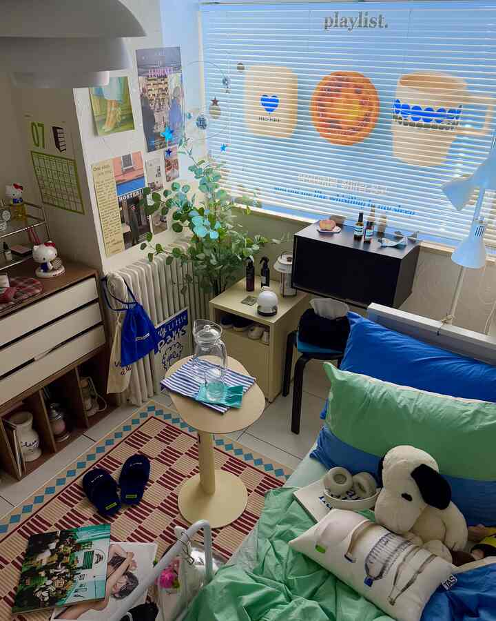 Blue and white toned bedroom featuring blue bedding, side table, and natural plants in a cozy interior