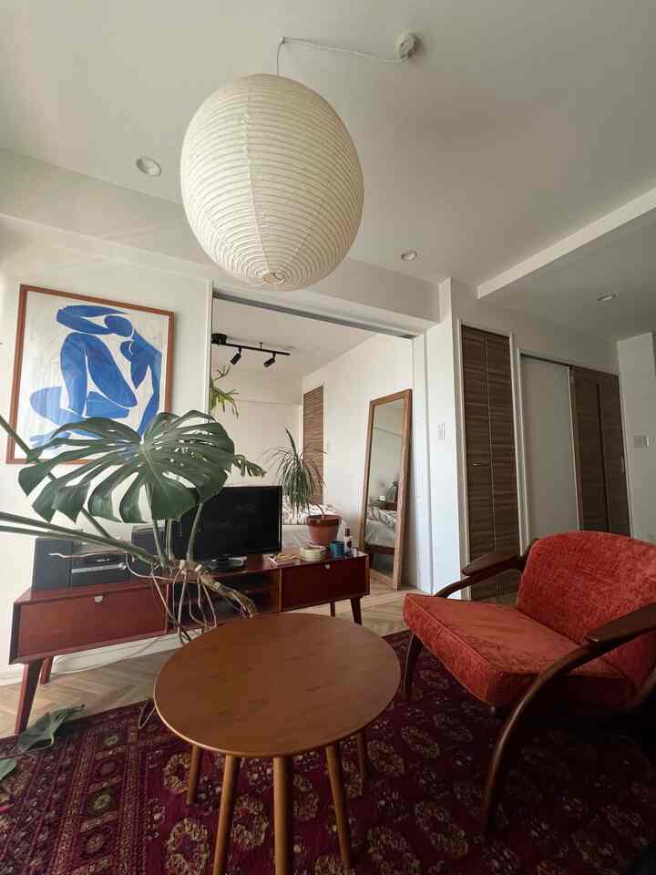 Natural color living room featuring an orange armchair and round coffee table in a cozy setting
