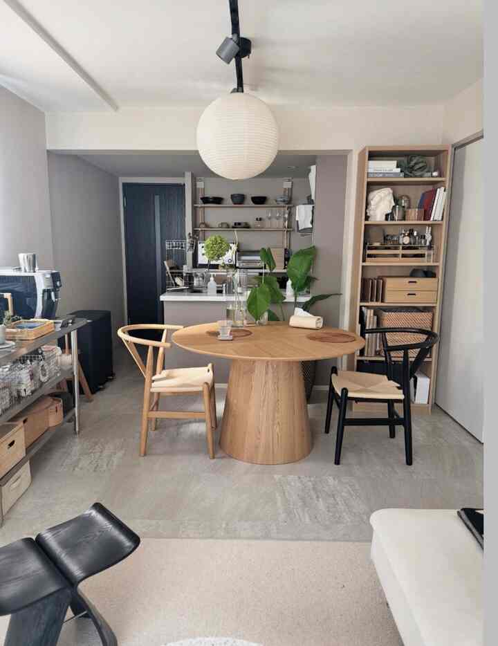 A simple Nordic-style dining room in natural wood tones, featuring a round dining table and designer chairs creating a cozy atmosphere