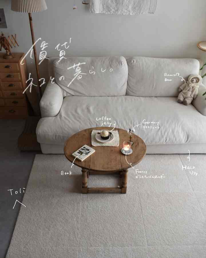 ナチュラルな色調のリビング、ベージュのソファと丸いローテーブルにコーヒーゼリーと手作りのインテリアが配置された落ち着いた空間