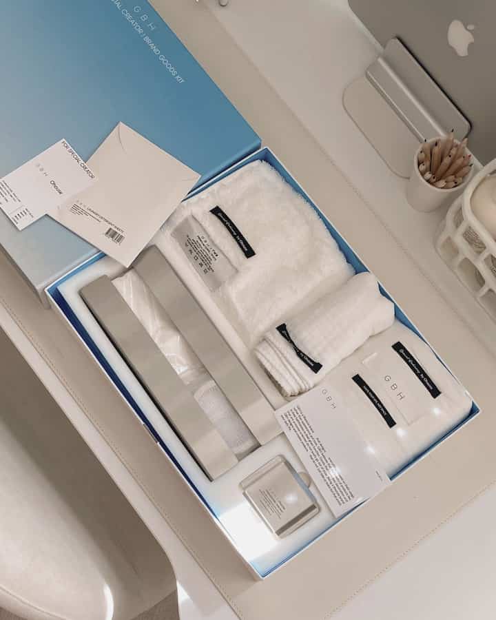 白とベージュの落ち着いた色調のデスクに、生活雑貨であるタオルやトレイが整理されて配置されたホームオフィスの雰囲気あるインテリア