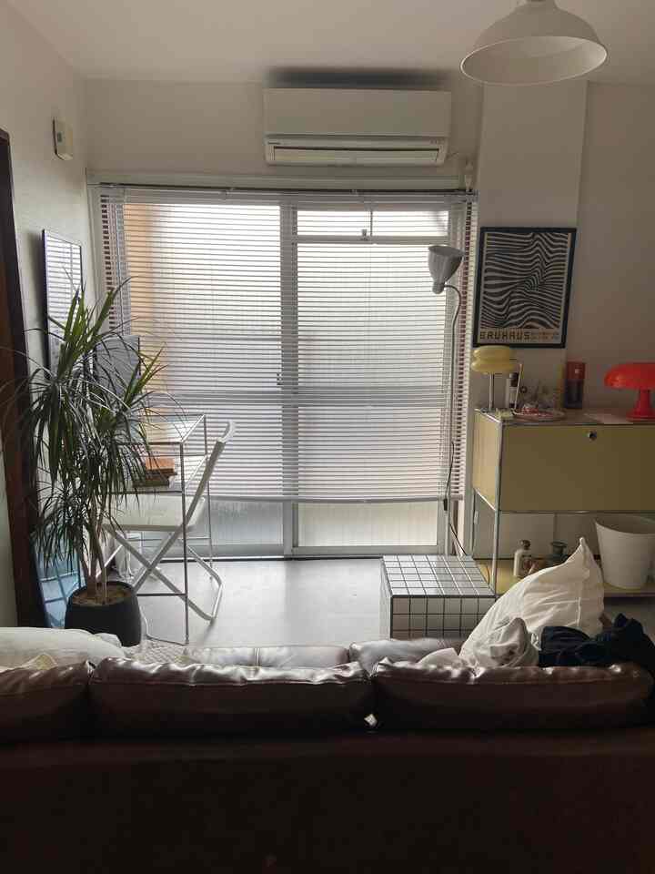 白と茶色のトーンの一人暮らしリビング、ミッドセンチュリーモダンの家具と整ったレイアウトの印象的な空間