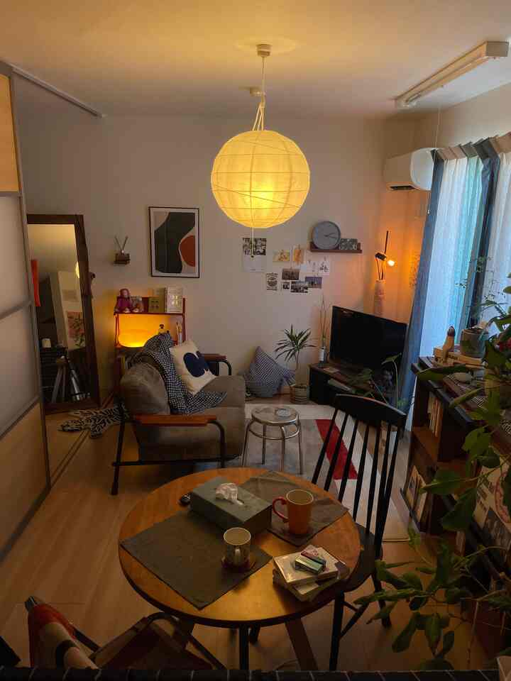 白い壁とブラウンの木目調家具が調和した40㎡の二人暮らし用リビングダイニング、植物とポスターが配された温かみのある空間