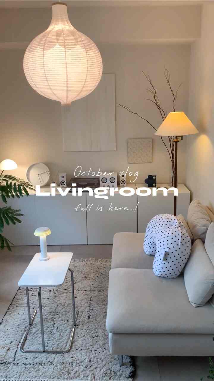 白とベージュの色調のリビング、ソファとサイドテーブル、フロアランプが配置された自然で間接照明のある雰囲気のインテリア