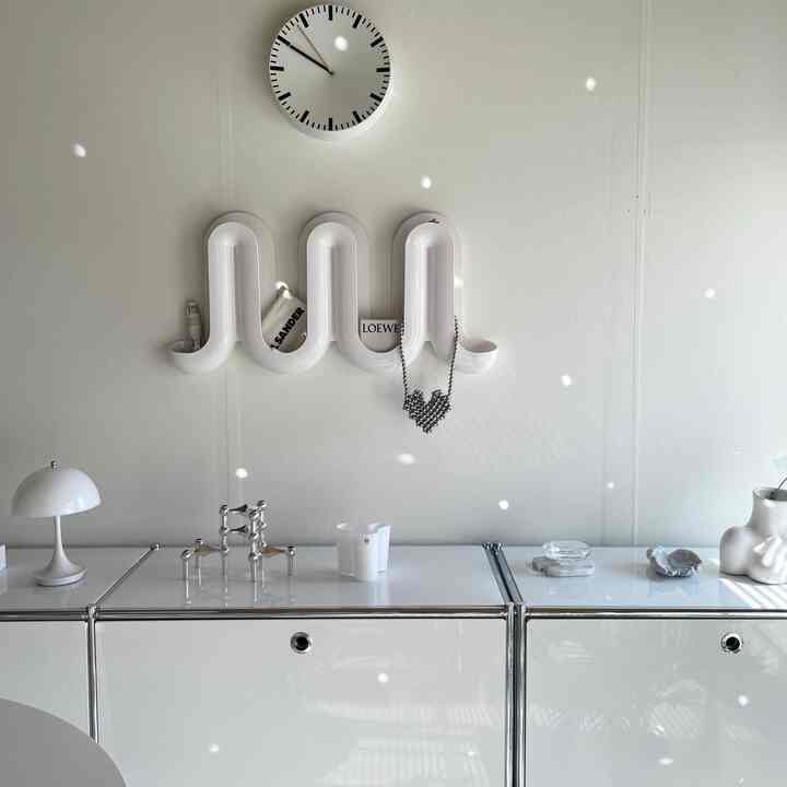 Minimal living space with white walls and cabinets, featuring simple design and modern accessories