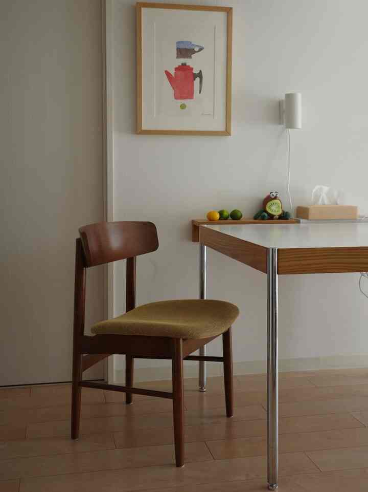 白い壁面と木製のダイニングテーブル、チェアが配置されたナチュラルなダイニング空間