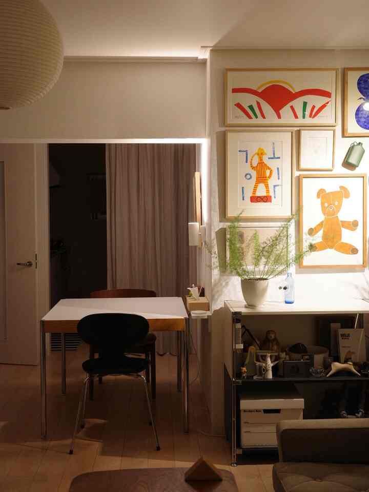 Natural toned bedroom-dining space featuring Arne Jacobsen chairs, wall sconce lighting, and cozy mood lighting ambiance
