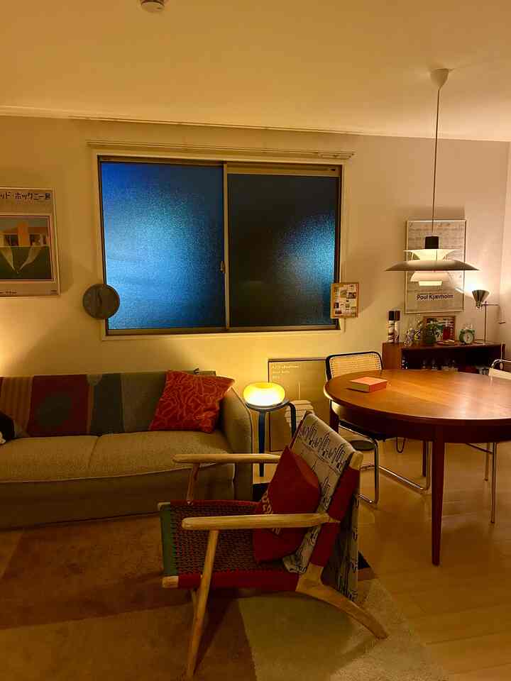 Warm natural-toned living and dining room featuring Louis Poulsen PH5 pendant light as focal point, cozy atmosphere