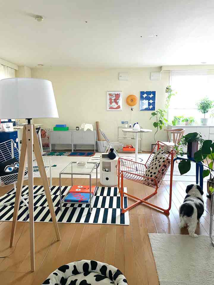 White and wood tone living room featuring an orange chair and a dog in a mid-century modern styled space