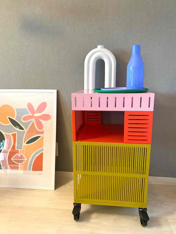 Bright, colorful storage trolley in a simple interior space with modern decorative elements