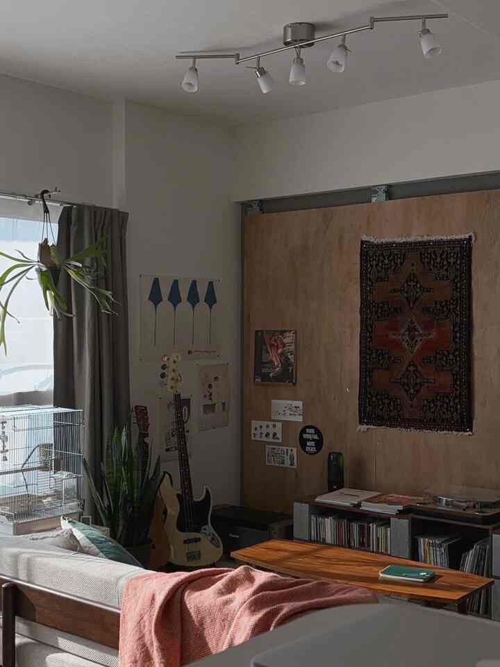 Natural-tone living room featuring sofa, wooden table, and musical instruments creating a warm atmosphere