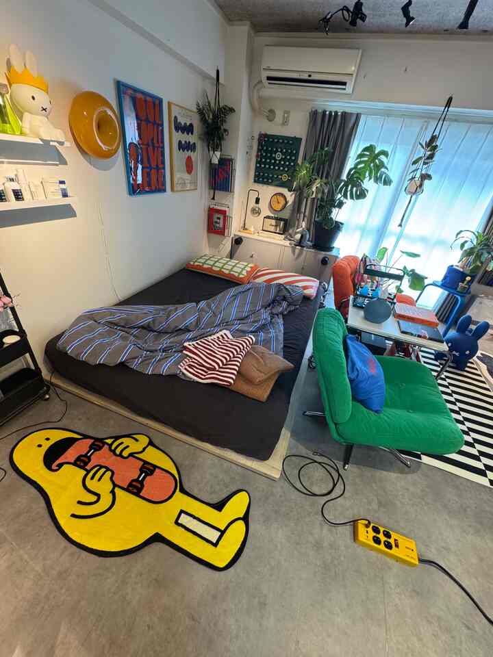 A white-walled, colorful Mid-Century Modern styled single household room with IKEA furniture in a combined living and bedroom space