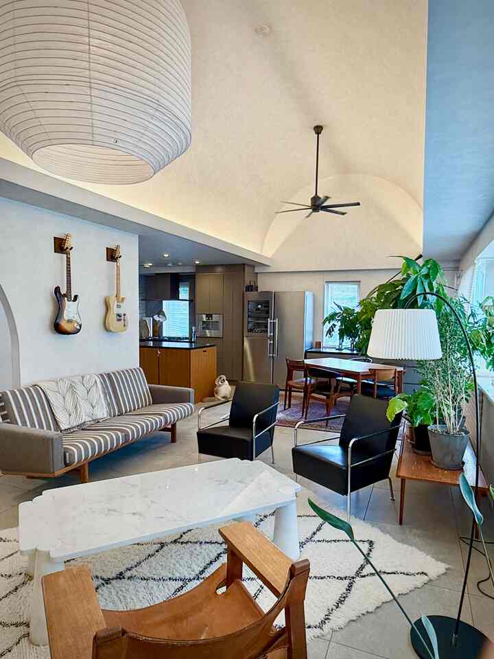 Natural color and wood tone living and dining room featuring Spanish chair and floor lamp in a cozy atmosphere