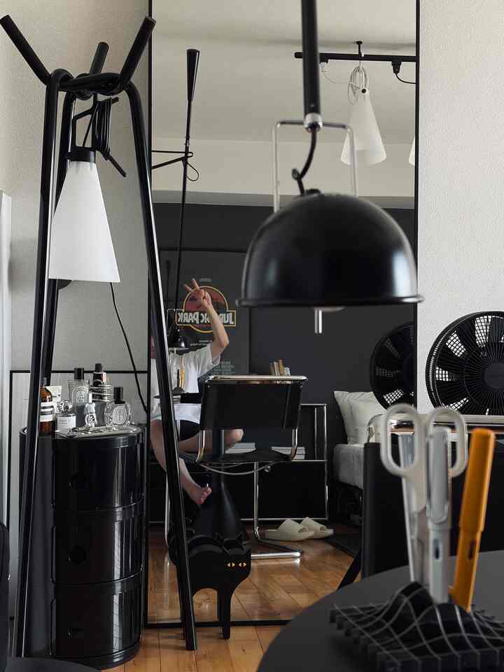 白と黒のモダンなリビングルーム、大きな鏡と猫のオブジェが配置された印象的な空間