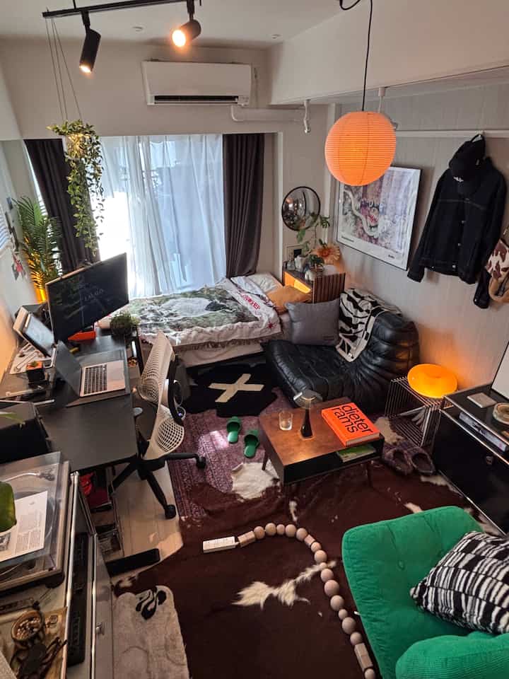 Orange-lit 8-tatami studio featuring mid-century modern furniture and a practical home office setup in a compact living space