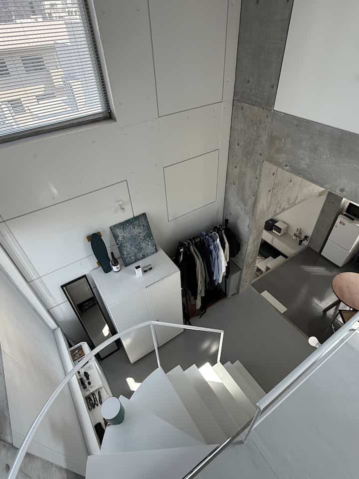 白とナチュラルカラーが調和する階段とリビングのミッドセンチュリーモダンなインテリア