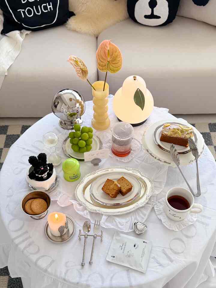 White tablecloth with silver series tableware, pink flowers, and lighting in a Korean interior cafe style space