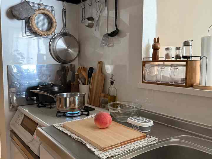 Natural and white tone kitchen space featuring a cutting board, pot, and organized kitchen utensils in a tidy atmosphere