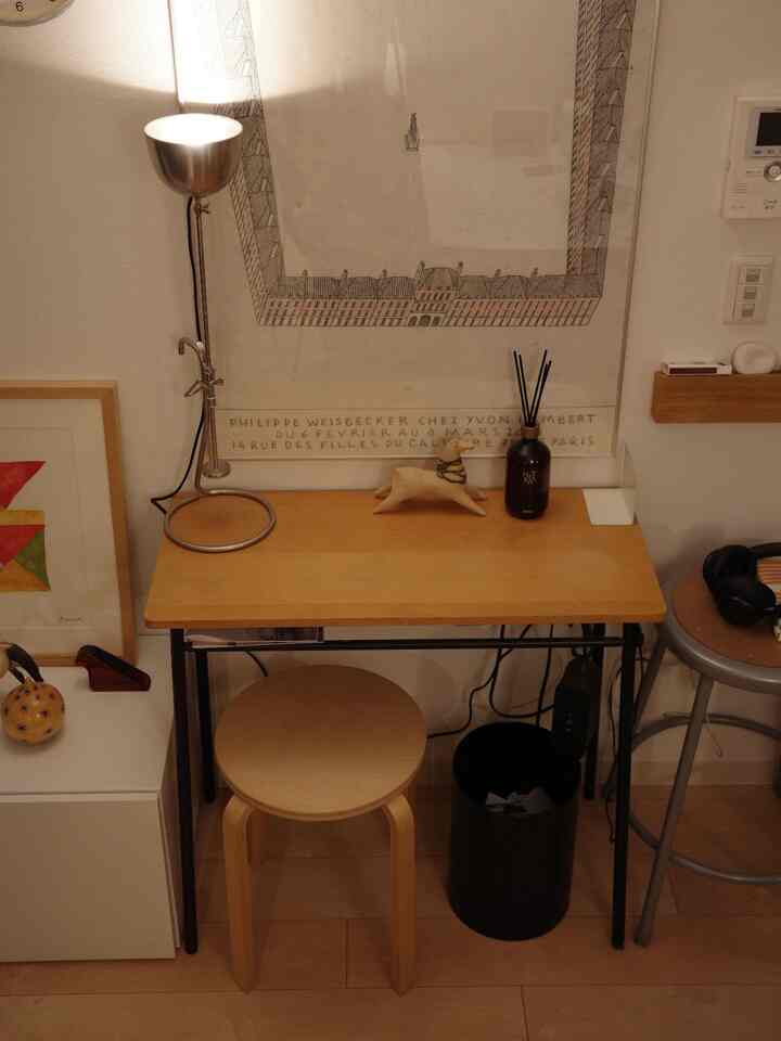 White walls and wood-tone console table with stool create a simple cozy mini workspace beside the dining room