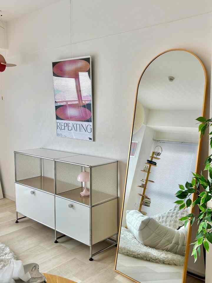 ホワイトとナチュラルカラーのリビング、USM HALLER収納と姿見が配置されたミニマルで清潔感のある空間