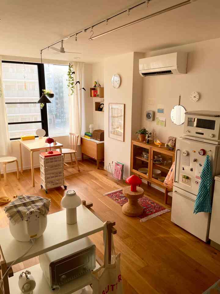 ナチュラルモダンのトーンでまとめられた1LDKのリビング兼ダイニング、収納家具やテーブルランプ、ダイニングテーブルが配置された温かみのある空間