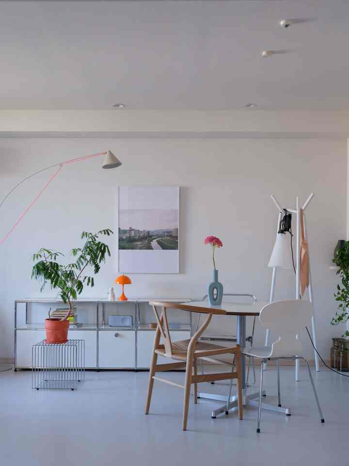 Natural modern living room in white and wood tones, featuring a round table and mixed chairs with a clean layout
