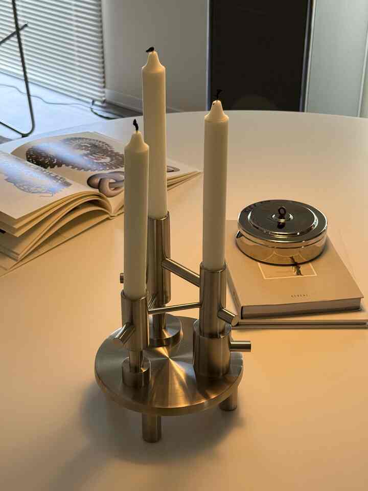 Minimal style white dining room with metallic tray holding candles and coasters centrally placed, creating a serene atmosphere