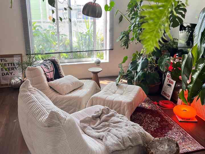 White and natural color living room featuring plants and comfortable sofas with a cozy atmosphere