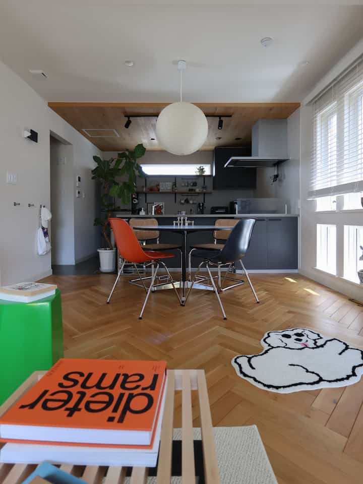 ブラウンの木目調床と白いペンダントライトがあるミッドセンチュリーモダンのダイニングルーム