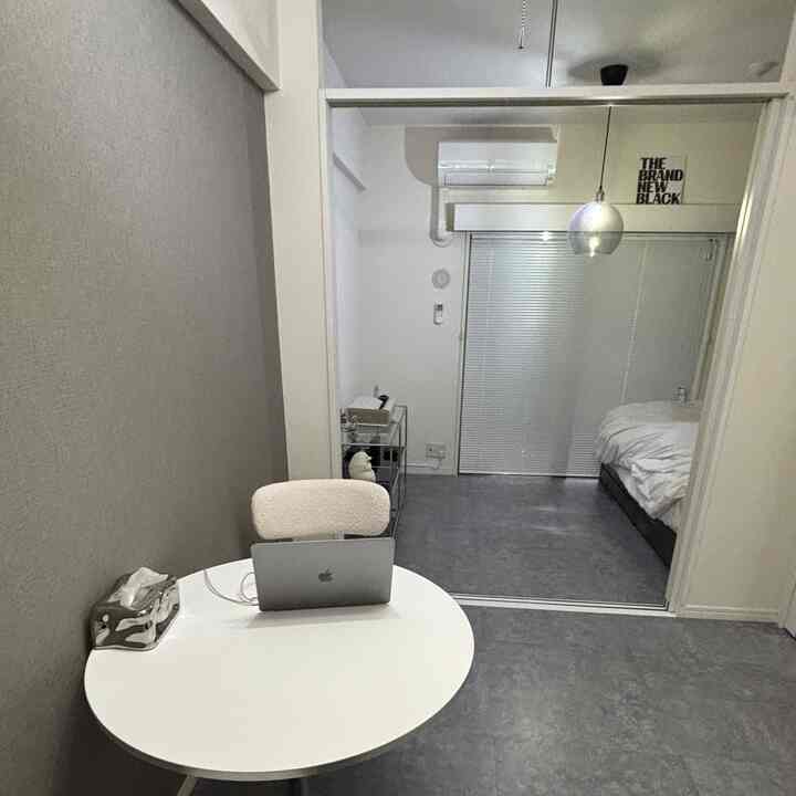 Gray-toned 2K studio featuring blinds and a simple home office workspace with a clean atmosphere