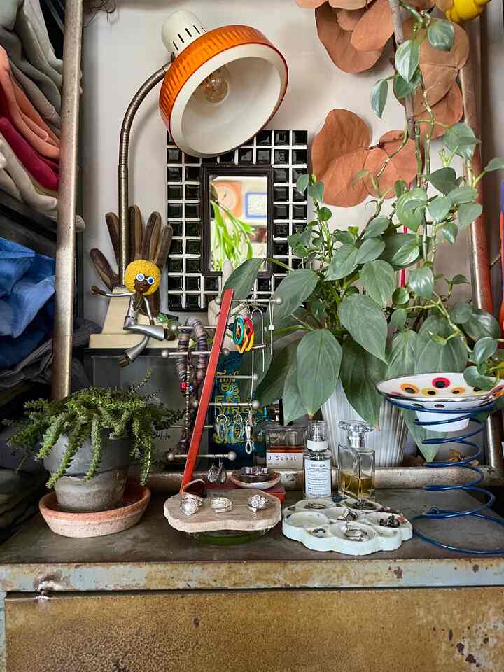 Natural color tones and red accents define the vanity area featuring plants and accessories with a cozy atmosphere