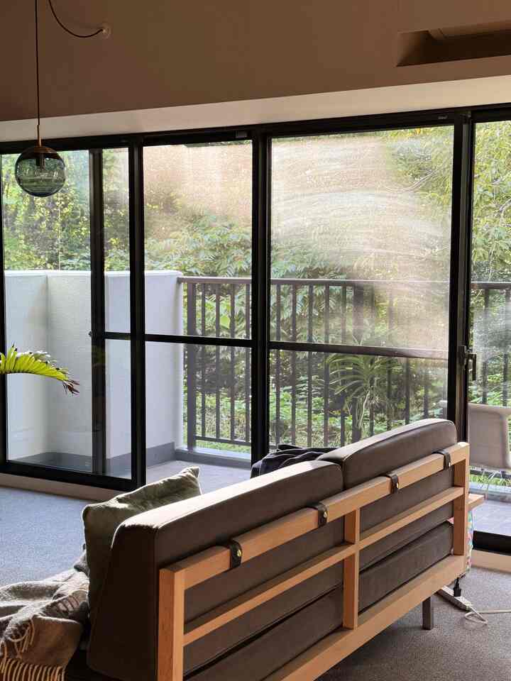 自然光が差し込むナチュラルモダンなワンルームリビング、木目調の家具が配置された印象的な空間