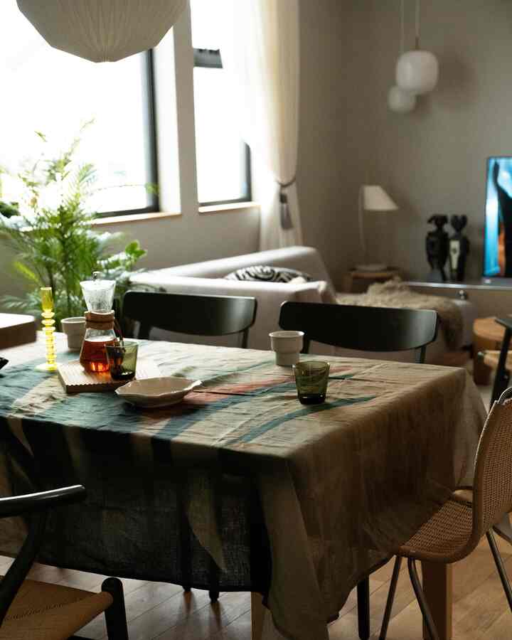 ナチュラルトーンのダイニング、リネンのテーブルクロスとコーヒー用品が配置された雰囲気のあるインテリア