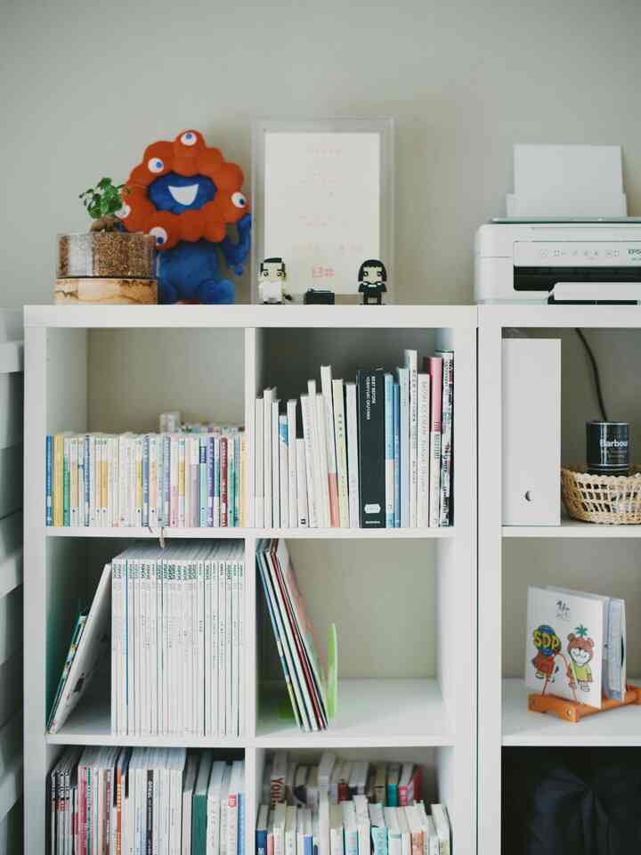White-toned bookshelf arranged in a neat study space, books and decor items organized creating a calm atmosphere