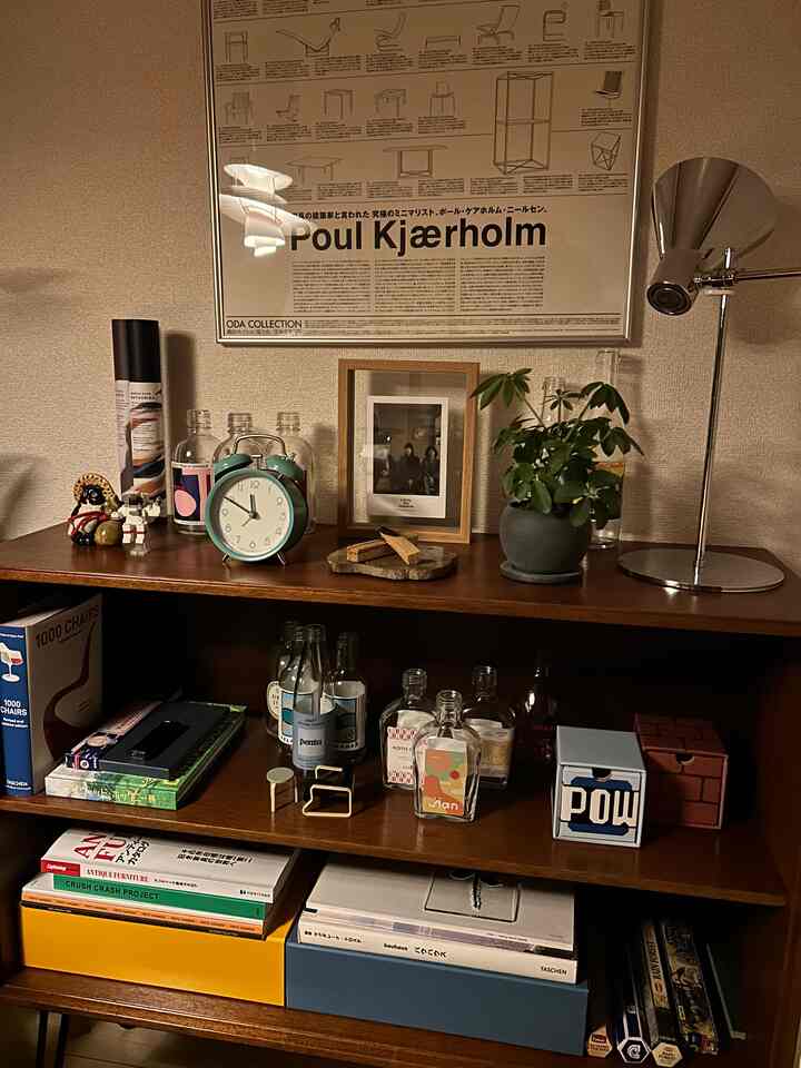 温かみのあるブラウンの木製キャビネットに空き瓶や小物が並ぶ、雰囲気のあるホームカフェ空間