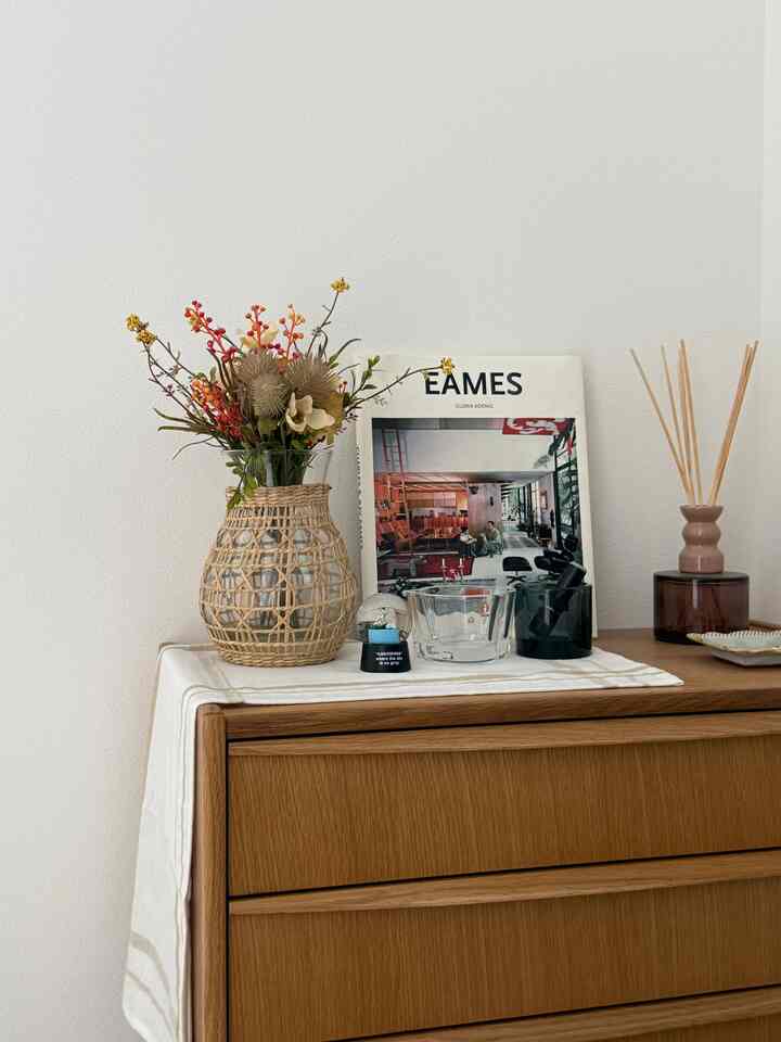 木目調と白の玄関、花瓶とキャンドルホルダーが配置されたシンプルでナチュラルな雰囲気のインテリア