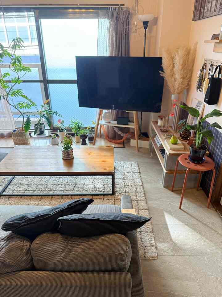 Bright beige-toned living room featuring natural wood furniture, sofa, coffee table, and TV, creating a cozy natural atmosphere