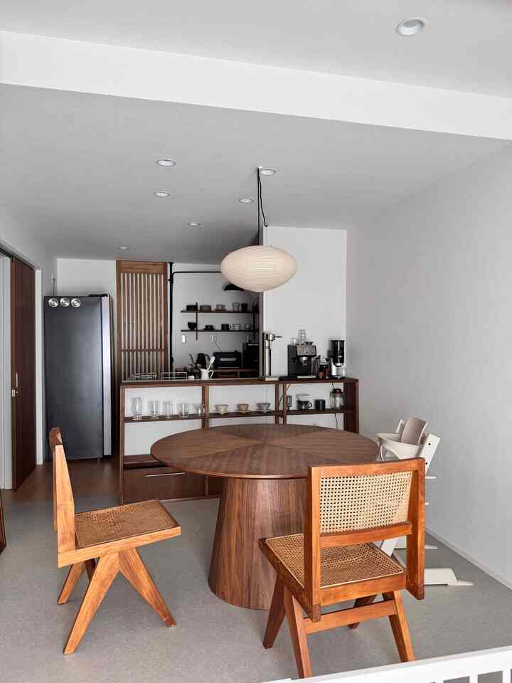 ナチュラルブラウンのトーンのダイニング、丸い木製ダイニングテーブルとペンダントライトが配置された雰囲気のあるジャパンディスタイルの空間